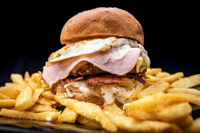 Close-up of burger on plate against black background