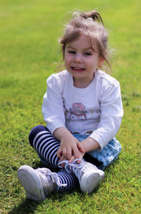Portrait of smiling girl sitting on grass