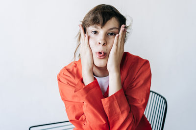 Portrait of young woman against white background