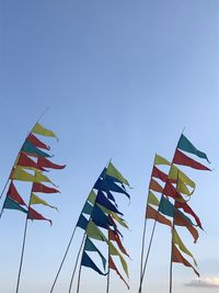 Low angle view of flags against clear sky