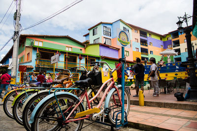 Bicycles on street in city against sky