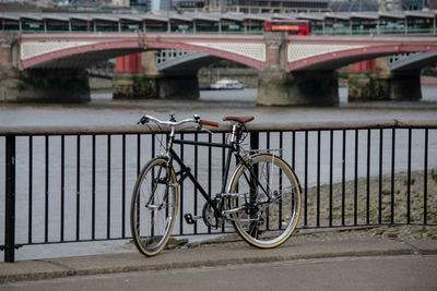 Bicycle on bridge over river in city