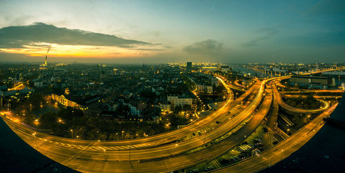 High angle view of illuminated city against sky at dusk