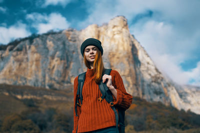 Young woman wearing hat standing against sky