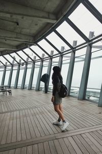 Rear view of woman walking on bridge