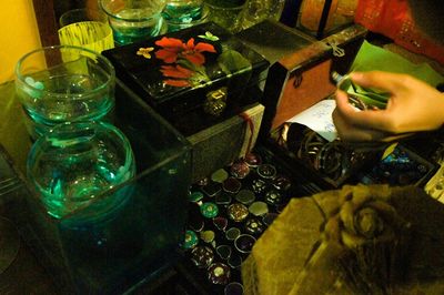 Close-up of hand holding glass of flower on table