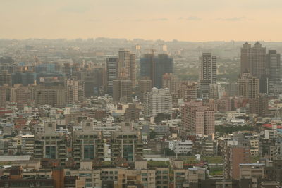 Aerial view of buildings in city against sky
