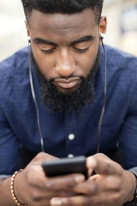 Man listening to music from mobile phone in city