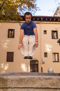 Full length of man jumping in artificial pond