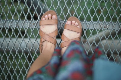 Low section of woman by chainlink fence
