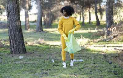 Young woman collecting garbage in park