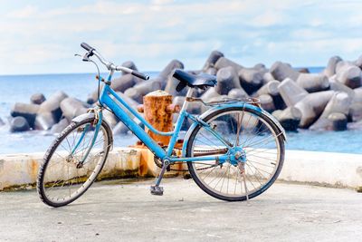 Bicycle on beach against sky