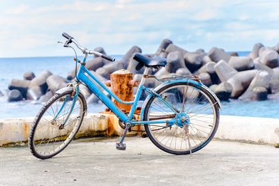 Bicycle on beach against sky