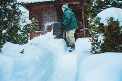 Man removing snow with shovel outside house