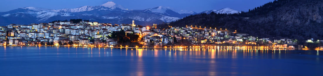 Panoramic view of illuminated buildings and mountains at night