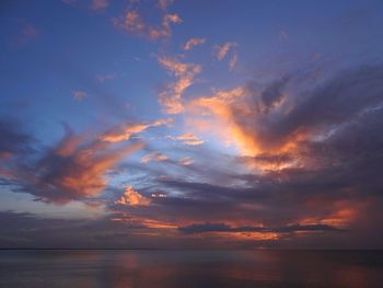 Scenic view of sea against dramatic sky during sunset