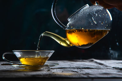 Close-up of drink pouring in glass on table