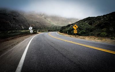 Empty road leading towards mountains