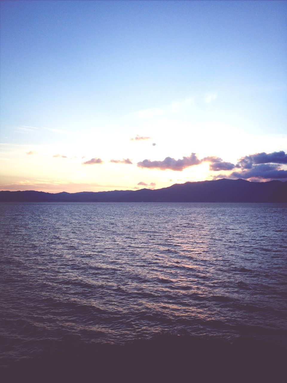 water, tranquil scene, scenics, sunset, tranquility, beauty in nature, sky, waterfront, sea, rippled, nature, idyllic, blue, cloud, silhouette, cloud - sky, reflection, calm, outdoors, lake