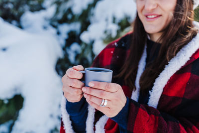 Close-up of woman holding coffee cup during winter