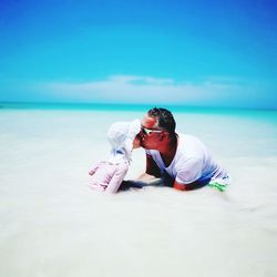 Man wearing sunglasses on beach against sky