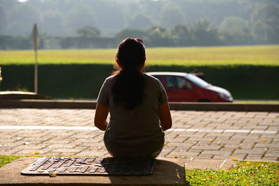 Rear view of a woman sitting outdoors