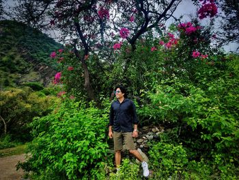 Full length of woman standing by tree against plants