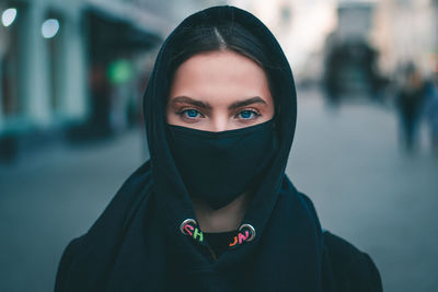Portrait of beautiful woman standing in city during winter
