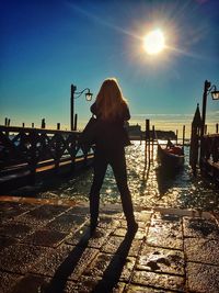 People standing on pier at sunset