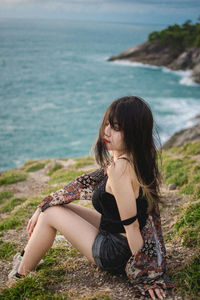 Woman sitting on sea shore