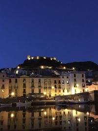 Illuminated buildings against clear sky at night