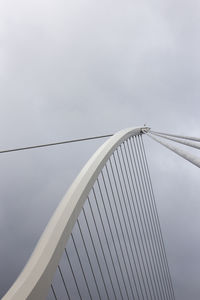 Low angle view of suspension bridge against sky