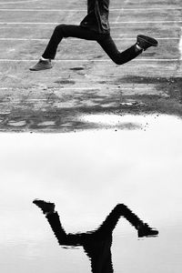 Low section of woman jumping in swimming pool