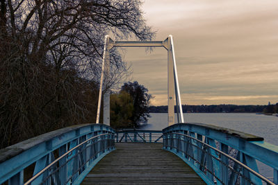 Walkway by bridge against sky