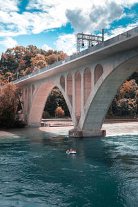 Arch bridge over river against sky