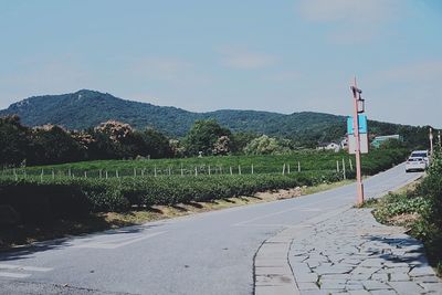 Road by mountain against sky