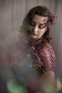 Close-up of woman with pink flower