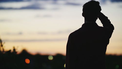 Rear view of woman overlooking blurred sky