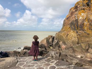 Rear view of girl looking at sea against sky