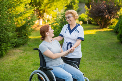 Portrait of senior woman riding push scooter on field