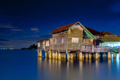 Building by sea against blue sky at night