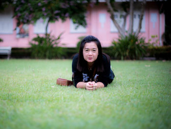 Portrait of woman lying on grassy field