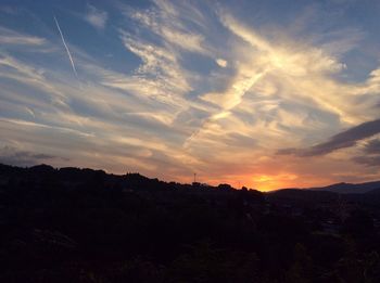 Scenic view of dramatic sky over silhouette landscape