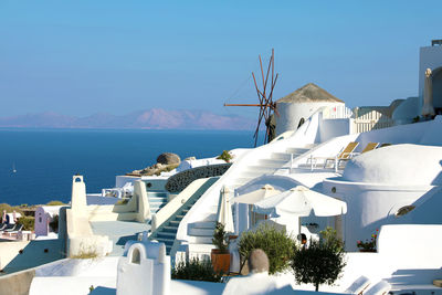 Buildings by sea against sky