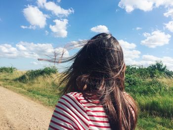 Rear view of woman standing on road