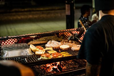 Midsection of man preparing food on grill