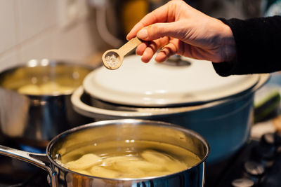 Close-up of hand pouring tea cup