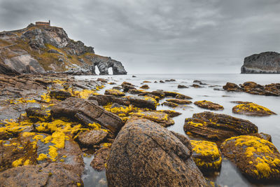 Rocks on beach against sky