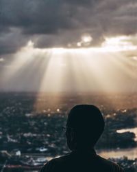 Man looking at view against cloudy sky during sunset