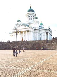 People in front of building against sky